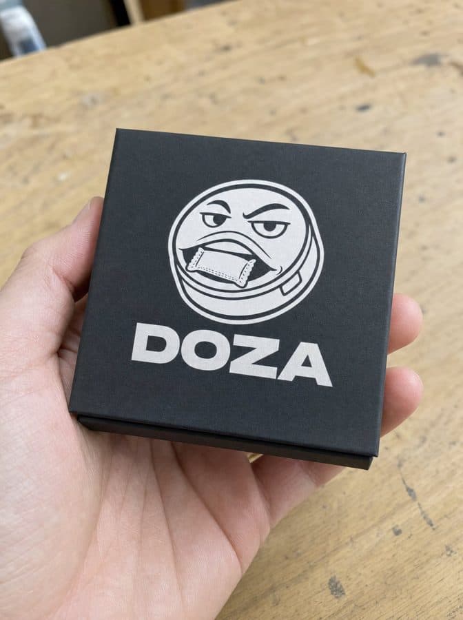 The black DOZA box held in a hand