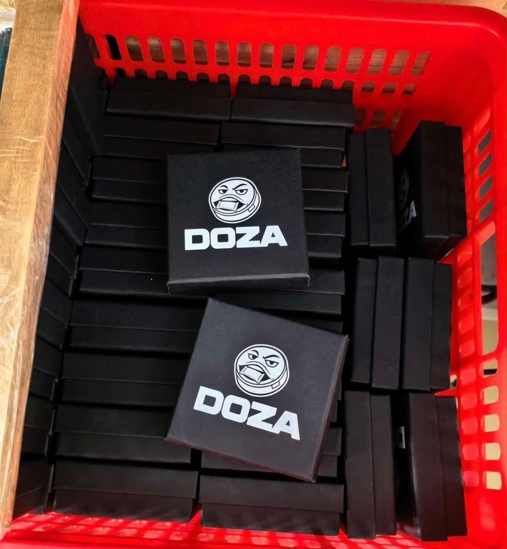 Black DOZA boxes stacked in a red factory crate